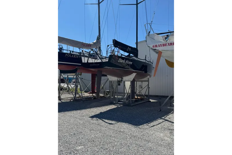 Slide: The Image of 2019 J Boats J/121 sailboat "Dark Storm" on stands, surrounded by other boats. - 33