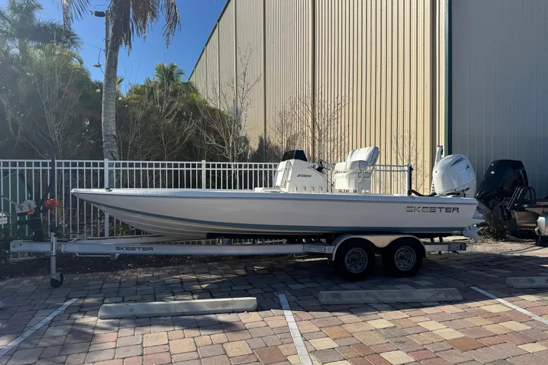 The Image of 2026 Skeeter SX221 boat on trailer, parked outdoors near a building. - 0