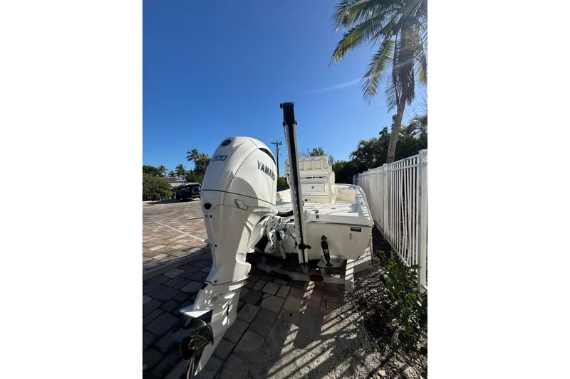 Slide: The Image of 2026 Skeeter SX221 boat with Yamaha engine, parked on a sunny day by palm trees. - 11