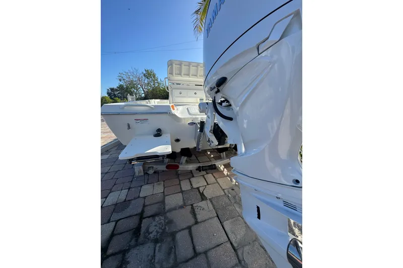 Slide: The Image of 2026 Skeeter SX221 boat rear view with outboard motor on paved surface. - 12