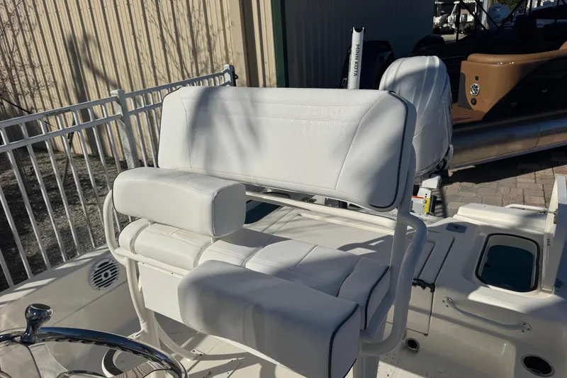 Slide: The Image of 2026 Skeeter SX221 boat with white cushioned seating and steering wheel. - 16