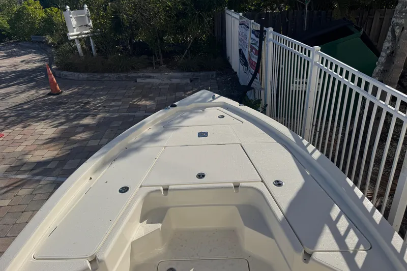 Slide: The Image of 2026 Skeeter SX221 boat deck, parked on a paved area with surrounding greenery. - 21