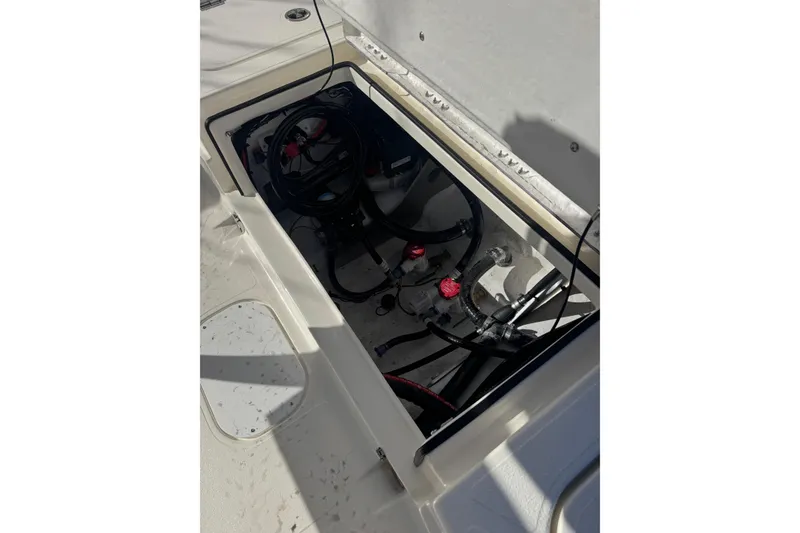 Slide: The Image of Open compartment of 2026 Skeeter SX221 boat showing internal wiring and components. - 22