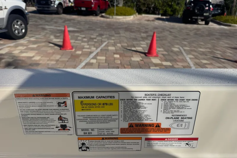 Slide: The Image of Warning labels and capacity information on a 2026 Skeeter SX221 boat. - 25
