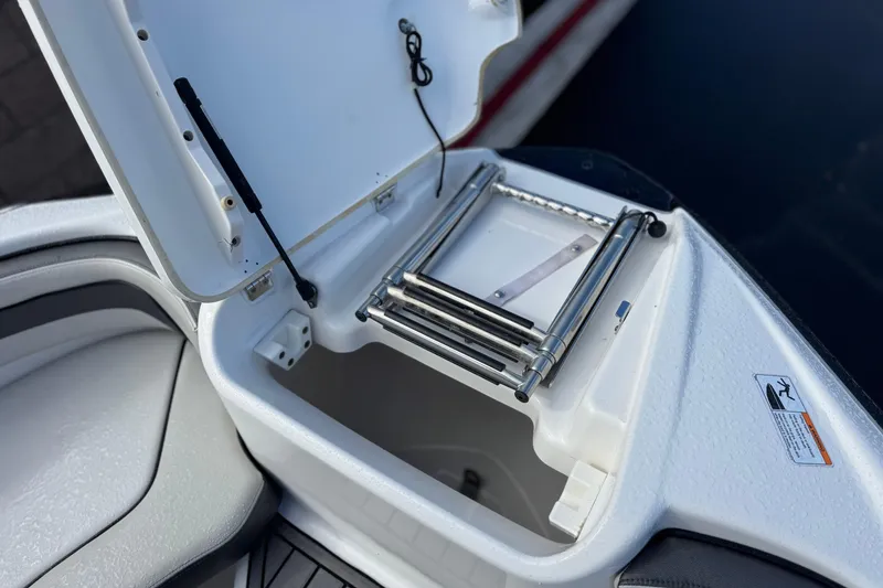 Slide: The Image of Open storage compartment with ladder on 2018 Yamaha AR240 boat. - 13