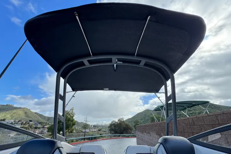 Slide: The Image of 2018 Yamaha Boats AR240 with canopy, scenic mountain backdrop, and cloudy sky. - 15