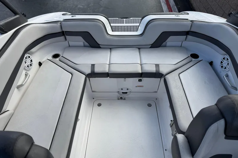 Slide: The Image of 2018 Yamaha Boats AR240 interior seating area with gray upholstery and built-in speakers. - 17