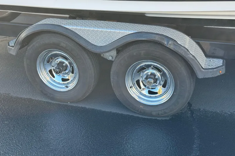 Slide: The Image of Trailer wheels of a 2018 Yamaha Boats AR240 on a textured surface. - 29