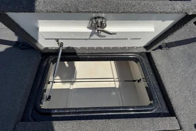Slide: The Image of 2022 Phoenix 721 ProXP boat storage compartment with open lid and secure latch. - 18
