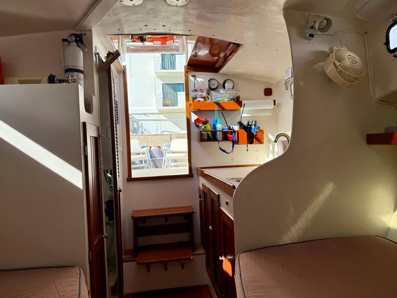 Slide: The Image of 1978 Dyer 29 Trunk Cabin interior with wooden accents and organized shelves. - 18