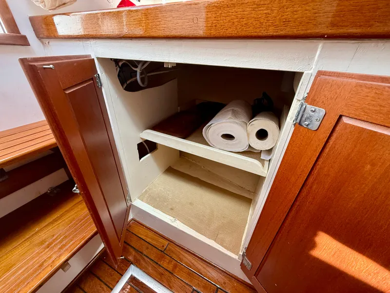 Slide: The Image of 1978 Dyer 29 Trunk Cabin interior with open wooden cabinet and storage shelves. - 20