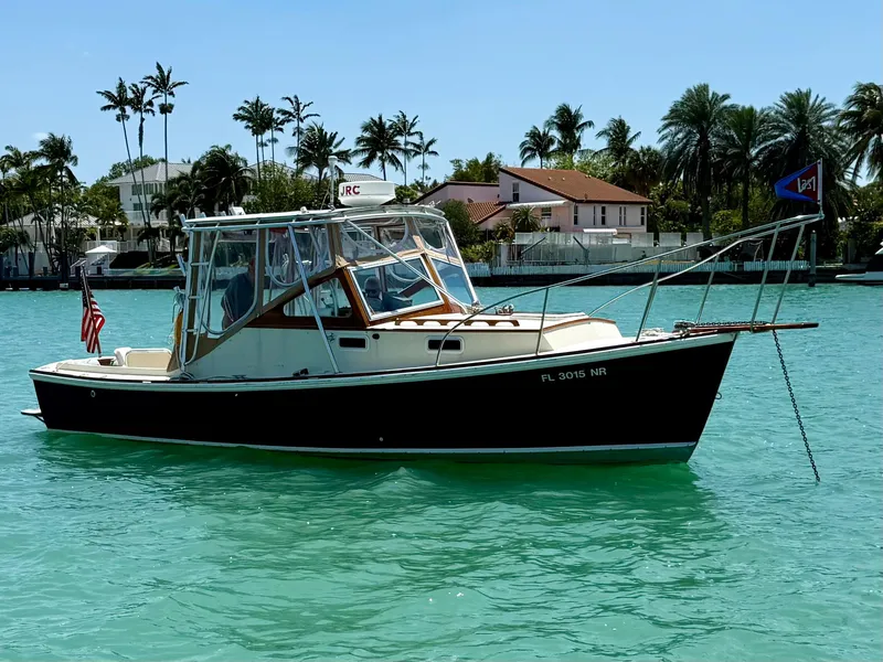 Slide: The Image of 1978 Dyer 29 Trunk Cabin boat on turquoise water, with palm trees in the background. - 31
