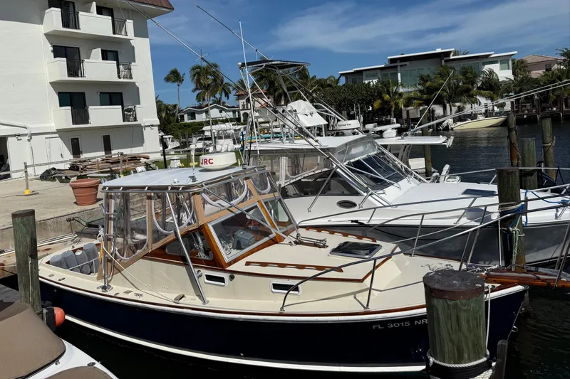 Slide: The Image of 1978 Dyer 29 Trunk Cabin boat docked at a marina under clear skies. - 5