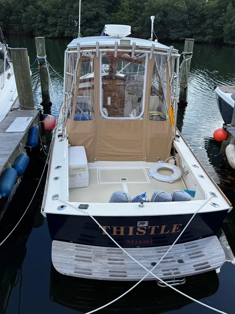 Slide: The Image of 1978 Dyer 29 Trunk Cabin boat named "Thistle" docked at a marina. - 8