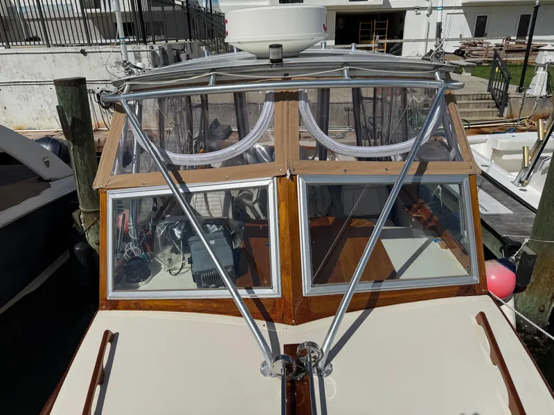 Slide: The Image of 1978 Dyer 29 Trunk Cabin boat with glass windows and metal supports at dock. - 9