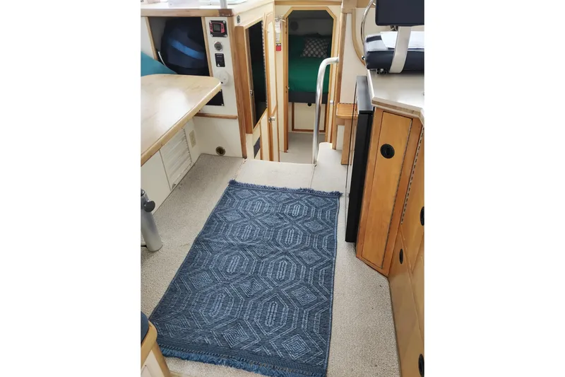 Slide: The Image of Interior of 2000 Albin 35 Tournament Express with blue patterned rug and wooden cabinetry. - 17