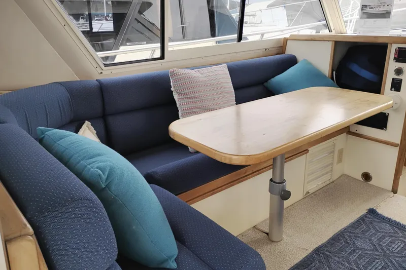Slide: The Image of Interior of 2000 Albin 35 Tournament Express with blue seating and wooden table. - 19