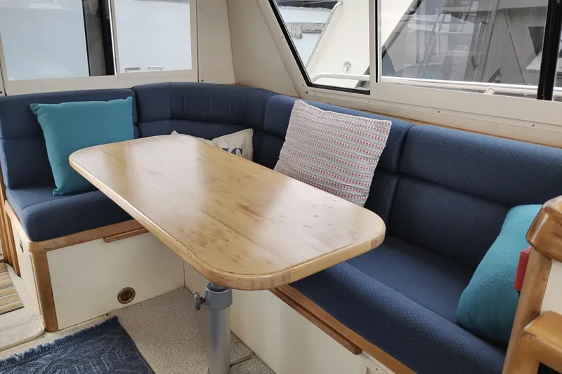 Slide: The Image of Interior of 2000 Albin 35 Tournament Express with blue seating and wooden table. - 20