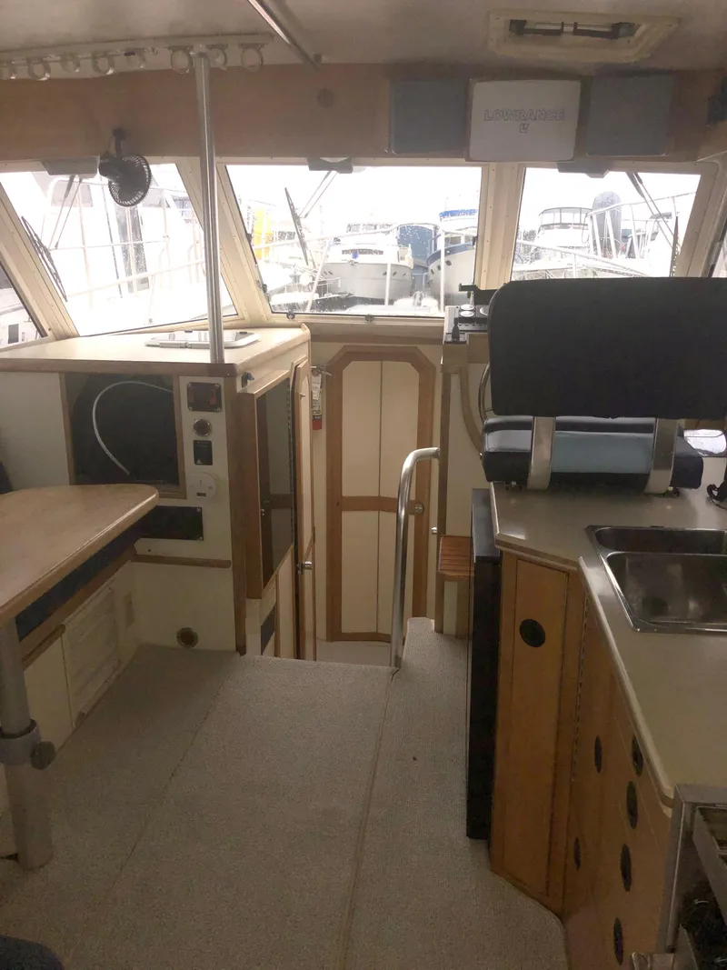 Slide: The Image of Interior of 2000 Albin 35 Tournament Express boat, featuring kitchen and seating area. - 22