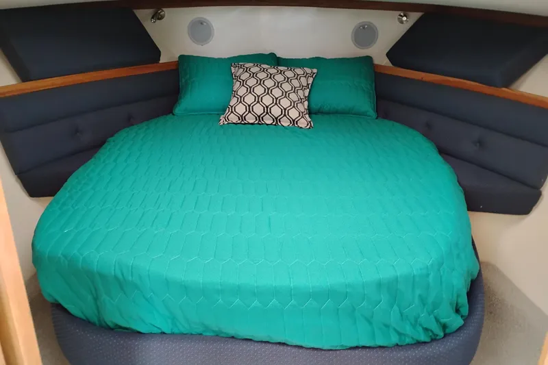 Slide: The Image of Cozy cabin bed in 2000 Albin 35 Tournament Express with teal bedding and decorative pillow. - 42