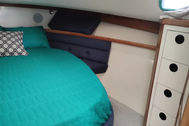 Slide: The Image of Interior cabin of 2000 Albin 35 Tournament Express with teal bedding and geometric pillow. - 43