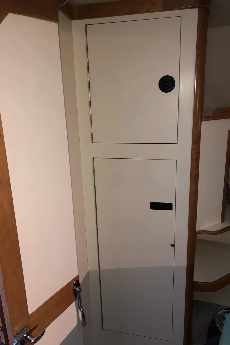 Slide: The Image of Interior of 2000 Albin 35 Tournament Express boat, featuring wooden cabinetry and storage compartments. - 44