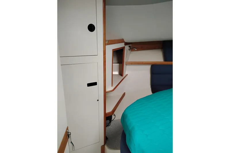 Slide: The Image of Interior cabin of 2000 Albin 35 Tournament Express with teal bedding and wooden accents. - 45