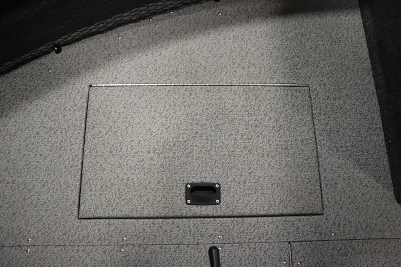 Slide: The Image of 2024 Crestliner 1950 Fish Hawk WT boat storage compartment with textured gray flooring. - 24