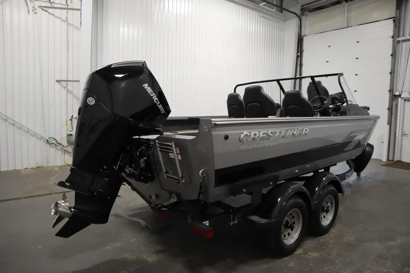 Slide: The Image of 2024 Crestliner 1950 Fish Hawk WT boat with Mercury outboard motor in a garage setting. - 5