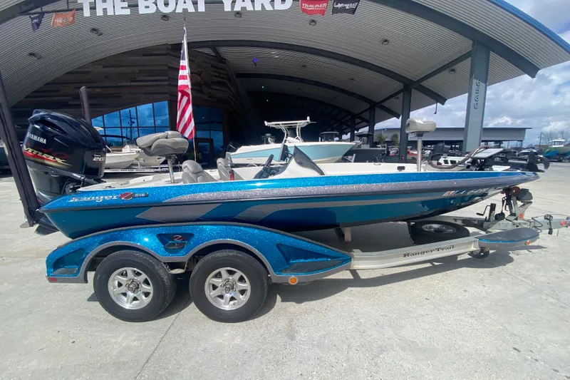 Slide: The Image of 2013 Ranger Z518 Intracoastal boat in blue, parked at a dealership with trailer. - 3