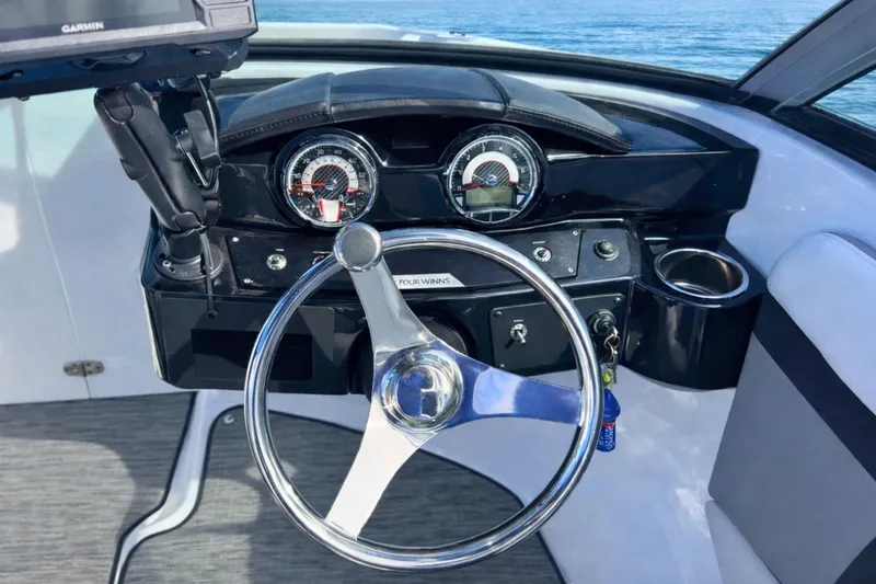 Slide: The Image of 2021 Four Winns HD1 OB boat dashboard with steering wheel and gauges. - 17