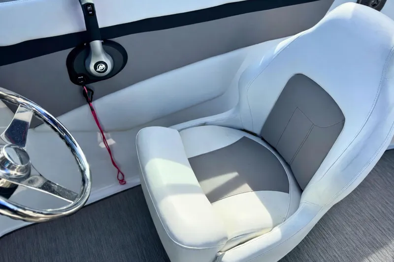 Slide: The Image of 2021 Four Winns HD1 OB boat interior with steering wheel and cushioned seat. - 19