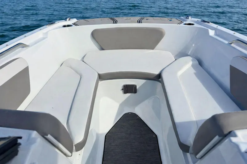 Slide: The Image of 2021 Four Winns HD1 OB boat interior with cushioned seating on calm water. - 22