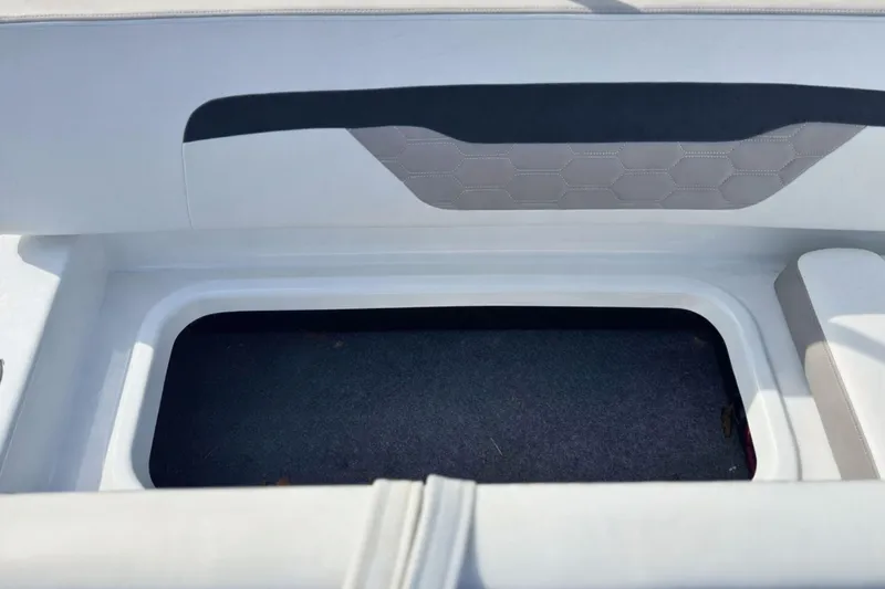 Slide: The Image of 2021 Four Winns HD1 OB boat storage compartment with cushioned seating and hexagonal pattern. - 9