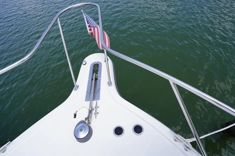 Slide: The Image of Bow of 2004 Tiara Yachts 2900 Open Classic with American flag over water. - 18