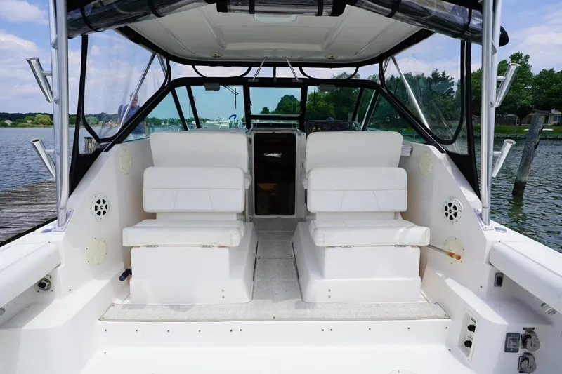 Slide: The Image of 2004 Tiara Yachts 2900 Open Classic interior with white seating and waterfront view. - 21