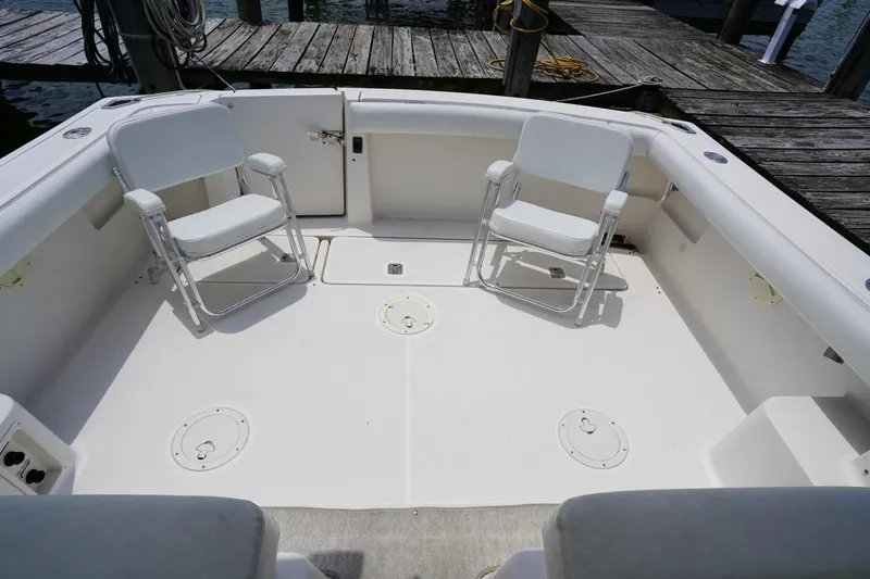 Slide: The Image of 2004 Tiara Yachts 2900 Open Classic deck with two white chairs, docked at marina. - 22