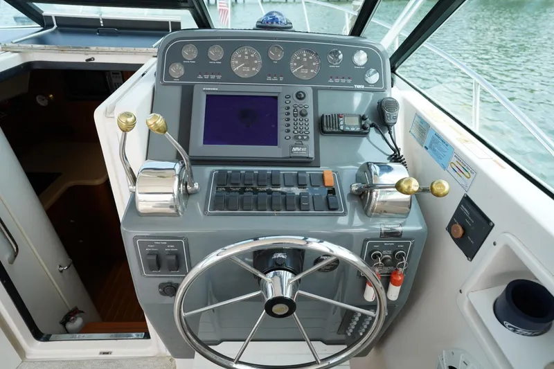 Slide: The Image of Helm of 2004 Tiara Yachts 2900 Open Classic with navigation controls and steering wheel. - 29