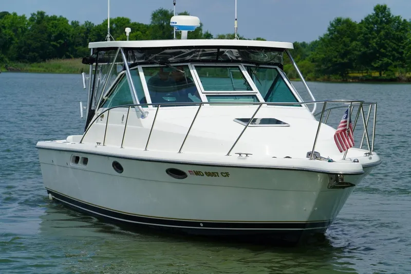 Slide: The Image of 2004 Tiara Yachts 2900 Open Classic boat on calm water with American flag. - 3