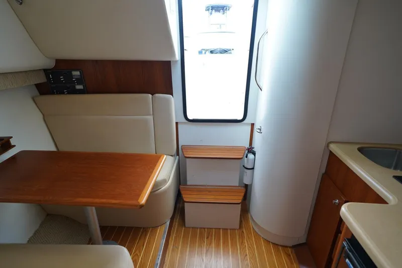 Slide: The Image of Interior of 2004 Tiara Yachts 2900 Open Classic, featuring seating, table, and kitchenette. - 34