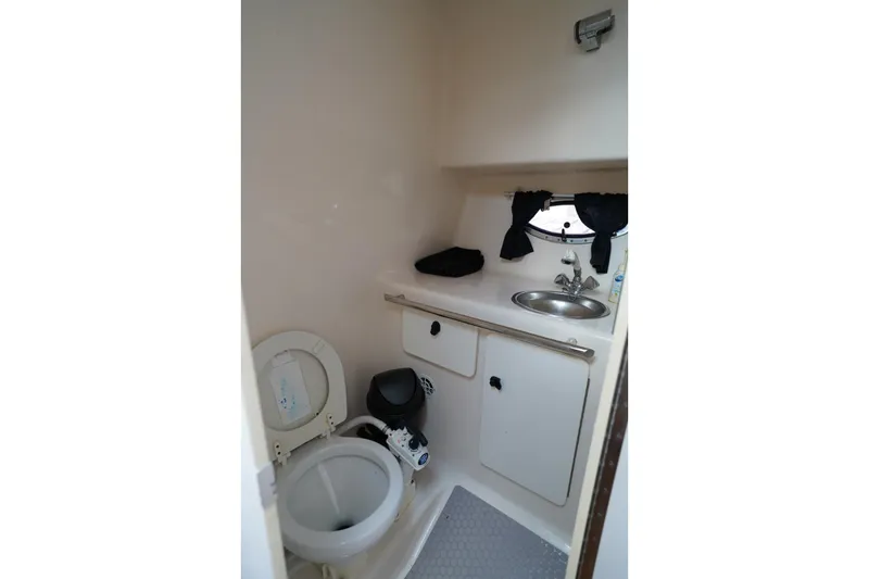 Slide: The Image of 2004 Tiara Yachts 2900 Open Classic bathroom with toilet, sink, and storage. - 41