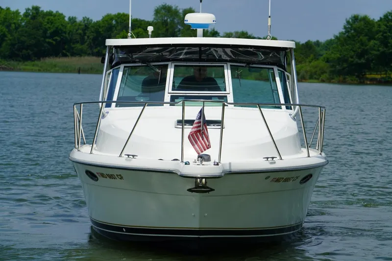 Slide: The Image of 2004 Tiara Yachts 2900 Open Classic boat on water, front view with American flag. - 5