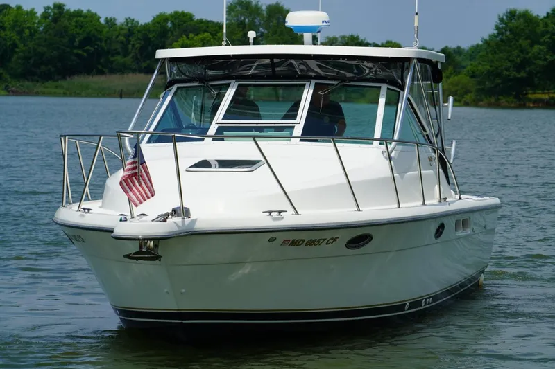 Slide: The Image of 2004 Tiara Yachts 2900 Open Classic boat on water with American flag. - 6