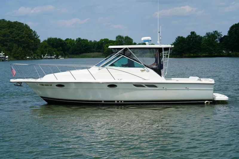 Slide: The Image of 2004 Tiara Yachts 2900 Open Classic on calm water, surrounded by trees. - 7