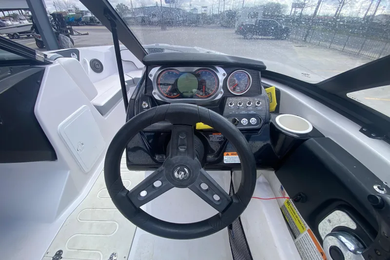 Slide: The Image of Cockpit view of 2018 Scarab 215 G boat with steering wheel and dashboard controls. - 14