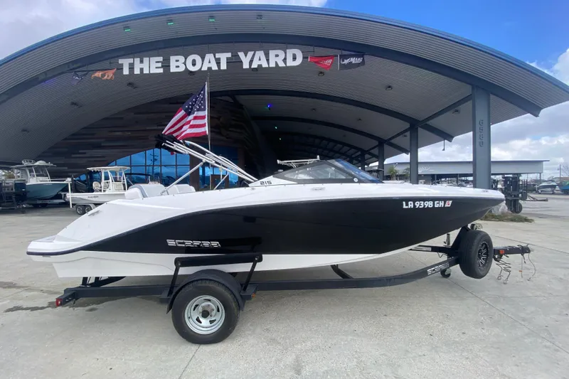 Slide: The Image of 2018 Scarab 215 G boat on trailer at The Boat Yard, American flag displayed. - 19