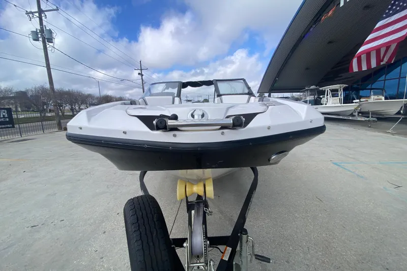 Slide: The Image of 2018 Scarab 215 G boat on trailer, parked outside dealership under cloudy sky. - 5