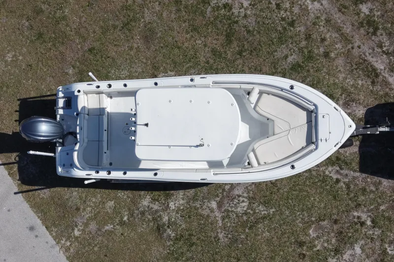 Slide: The Image of Aerial view of 2021 Sea Hunt Ultra 234 boat on grass, showcasing spacious deck layout. - 12
