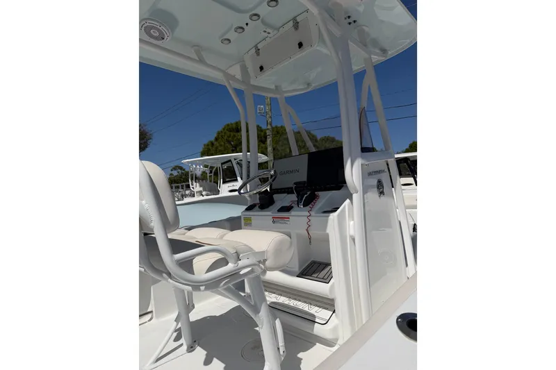 Slide: The Image of 2021 Sea Hunt Ultra 234 boat interior with steering console and seating. - 2
