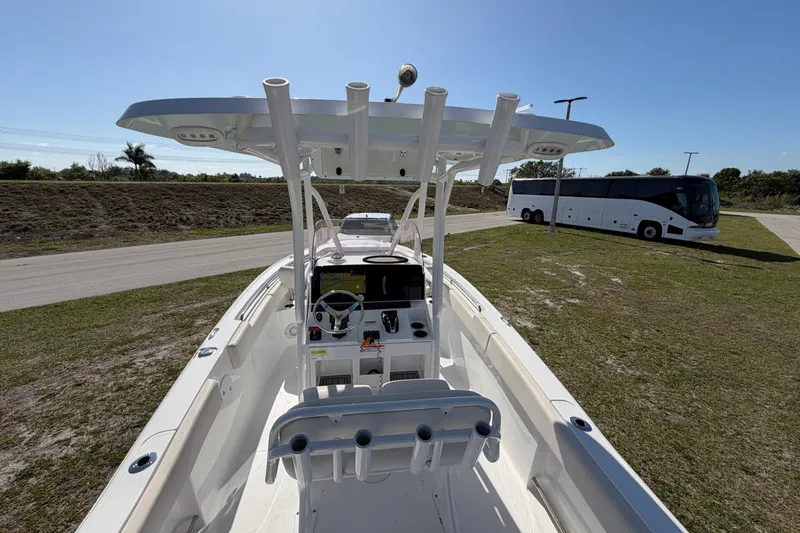 Slide: The Image of 2021 Sea Hunt Ultra 234 boat with T-top and console, parked on grassy area. - 22